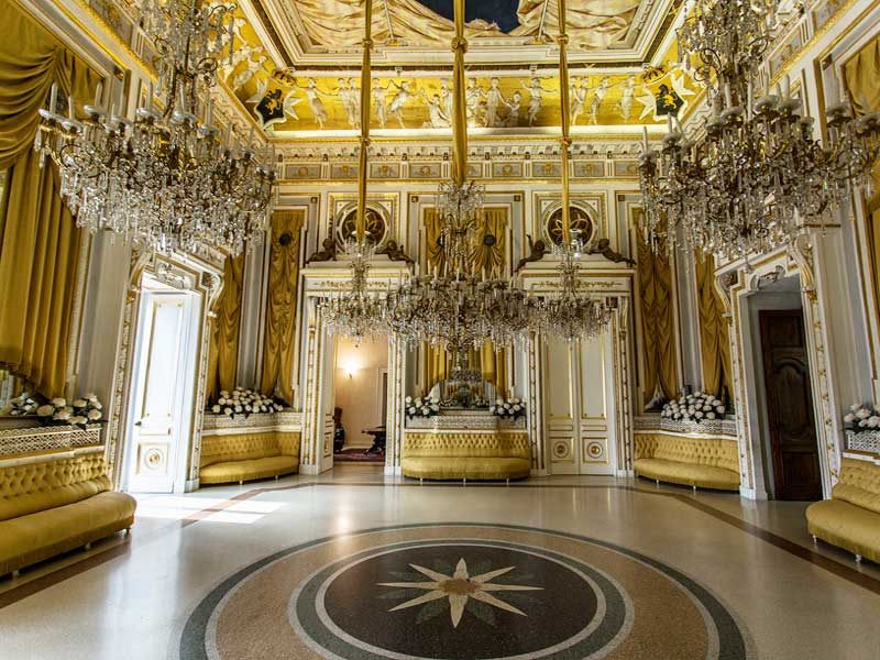 Richly decorated hall with chandeliers in the castle of Corigliano