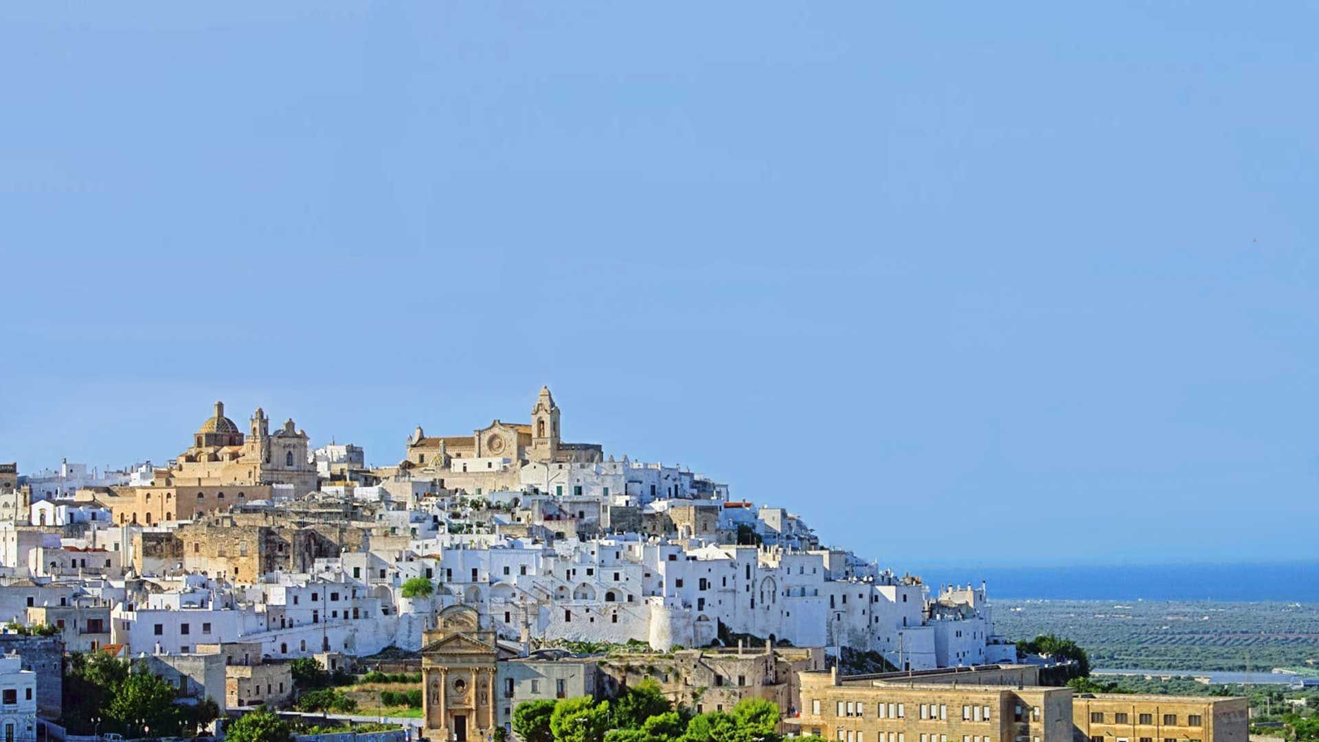 Die weiße Stadt Ostuni auf einem Hügel, mit dem Meer im Hintergrund