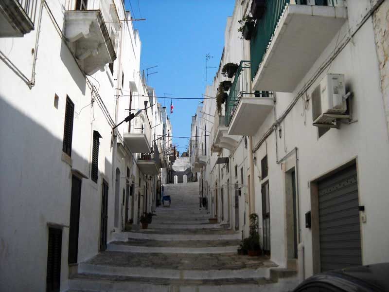 Schmale weiße Gasse mit Treppen in Ostuni