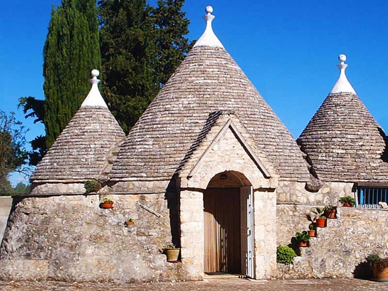 Trullo mit steinernen Kegeldächern und einer Holztür