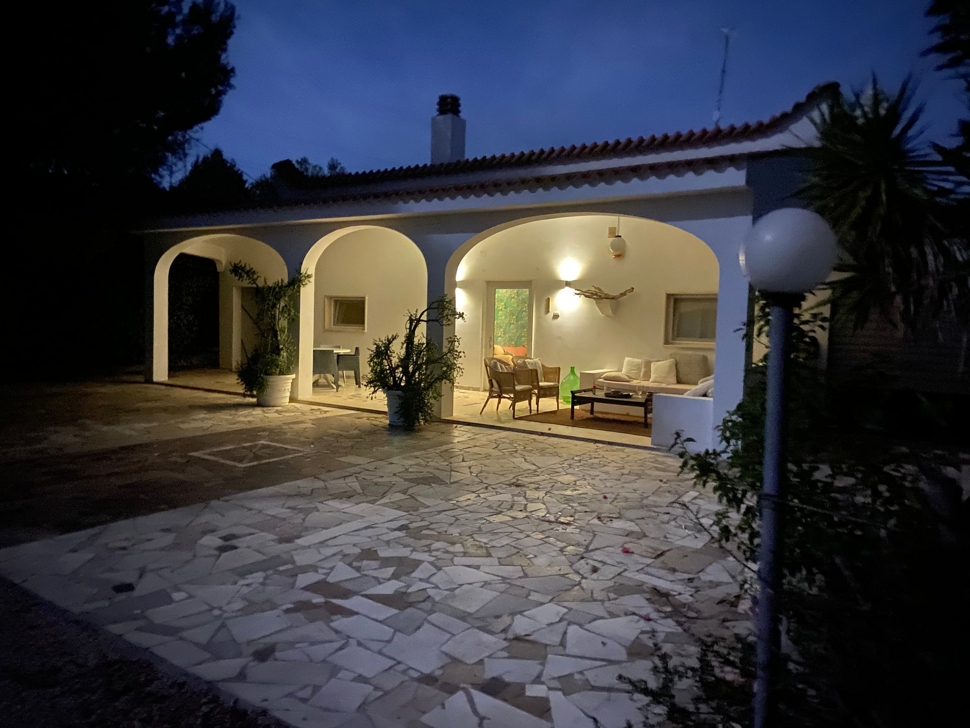 Villa Gabellotti am Abend, mit der beleuchteten Veranda unter den Bögen und der Terrasse