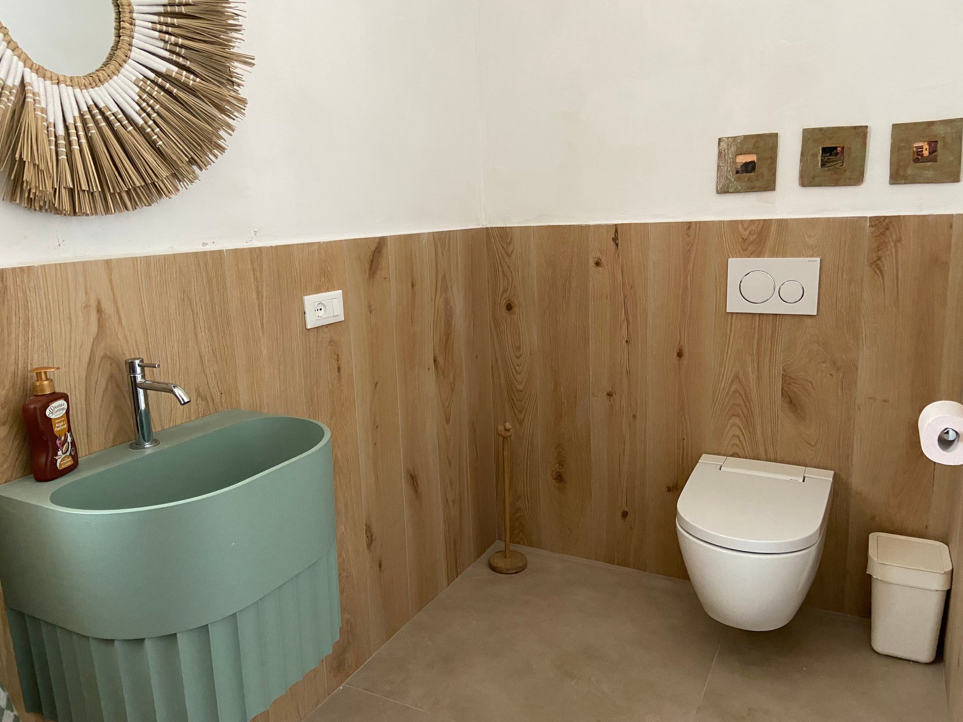 Badkamer van Villa Grimiti met een groene wastafel, houten lambrisering en een hangend toilet