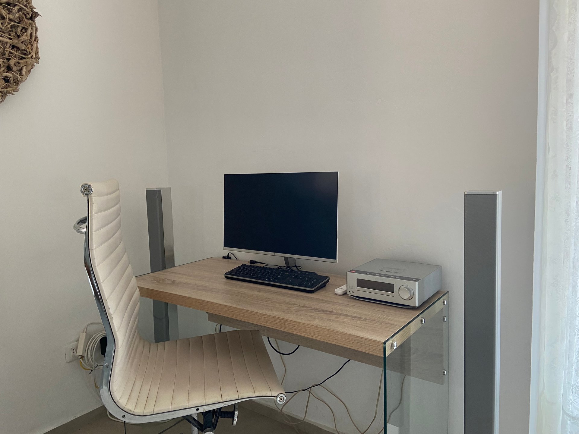 Werkplek in Villa Grimiti met een bureau, een beeldscherm en een witte bureaustoel